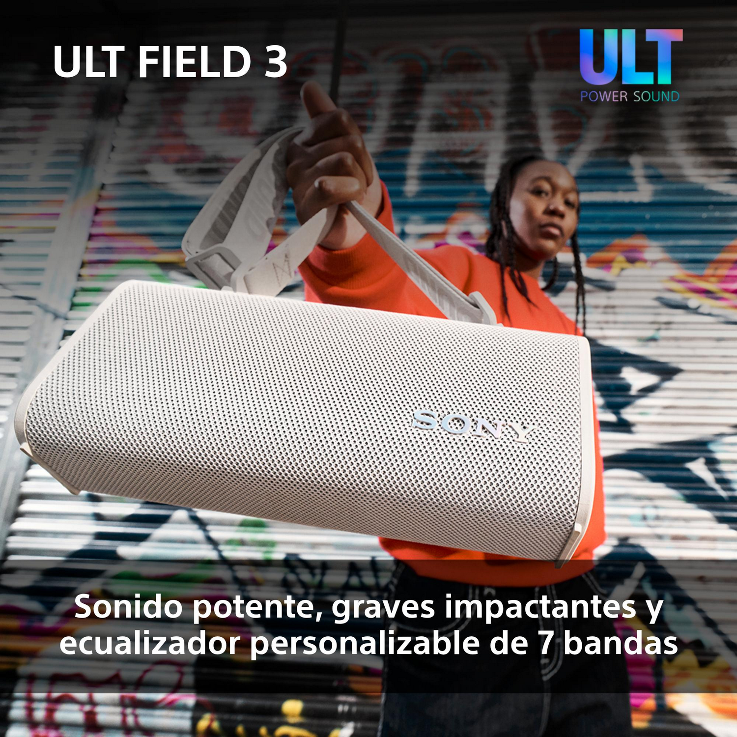 Una persona sosteniendo un altavoz blanco con el texto "ULT FIELD 3". Fondo de graffiti.