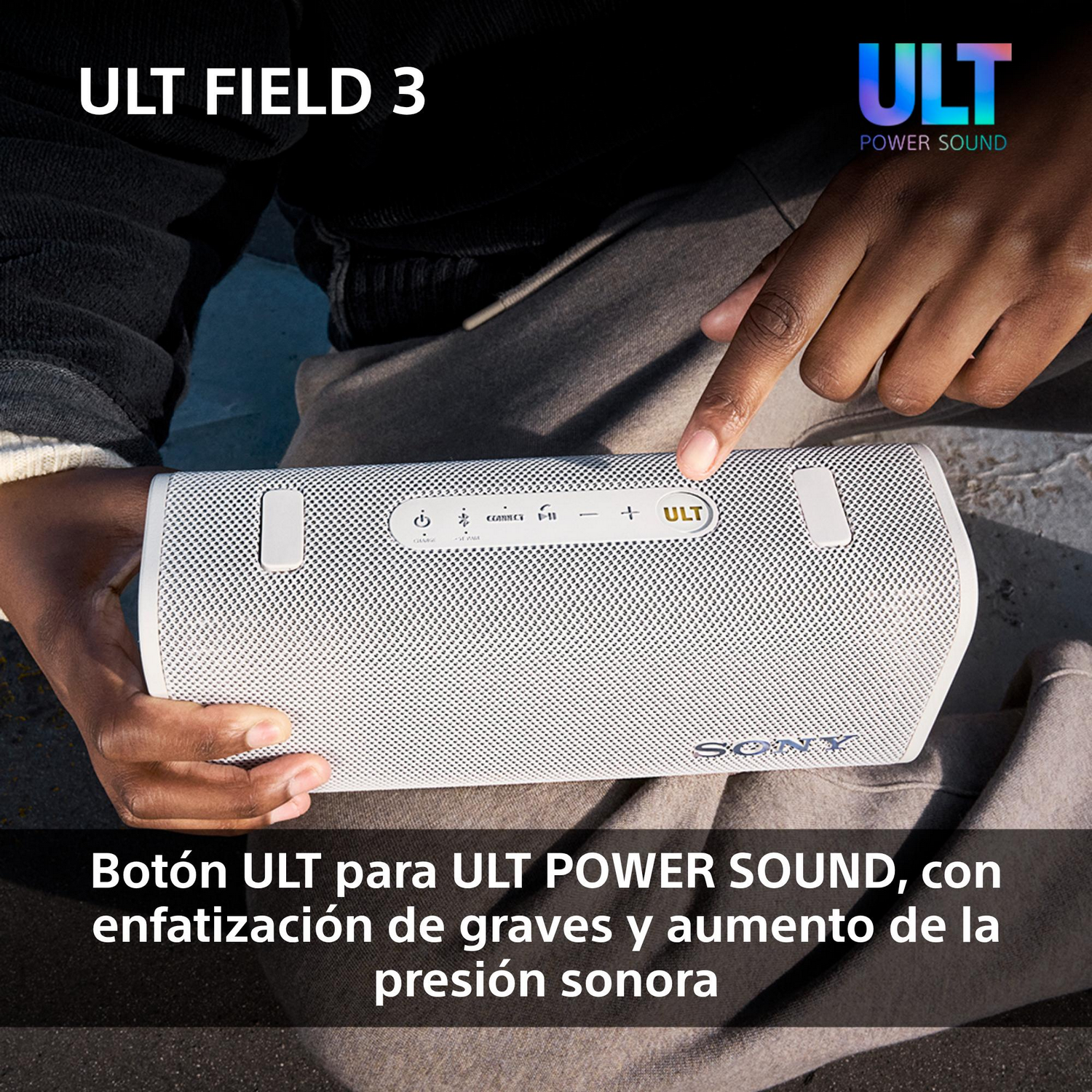 La mano de una persona señala un altavoz blanco con botones en la parte superior.