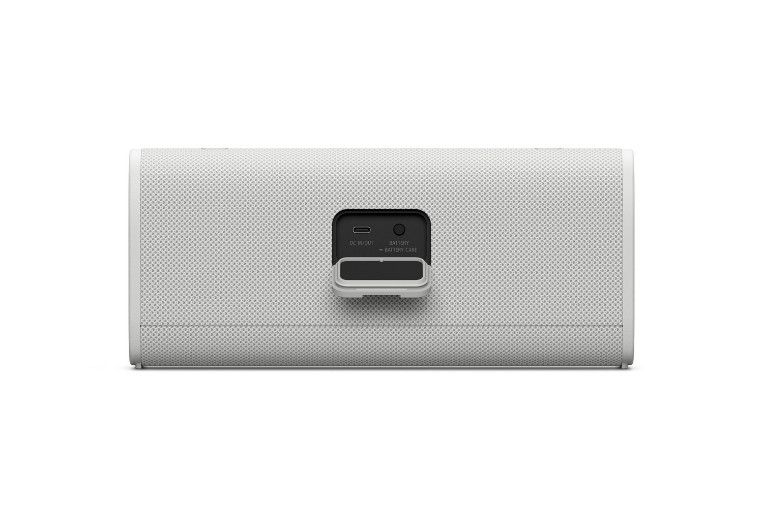 Altavoz blanco con superficie texturizada, puerto CC de entrada/salida y etiqueta de cuidado de la batería.