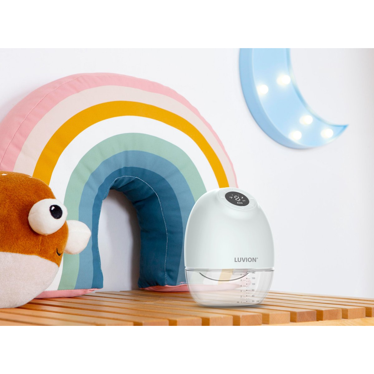 Witte babyflesverwarmer met een lichtblauwe maan en een regenboog op de achtergrond.