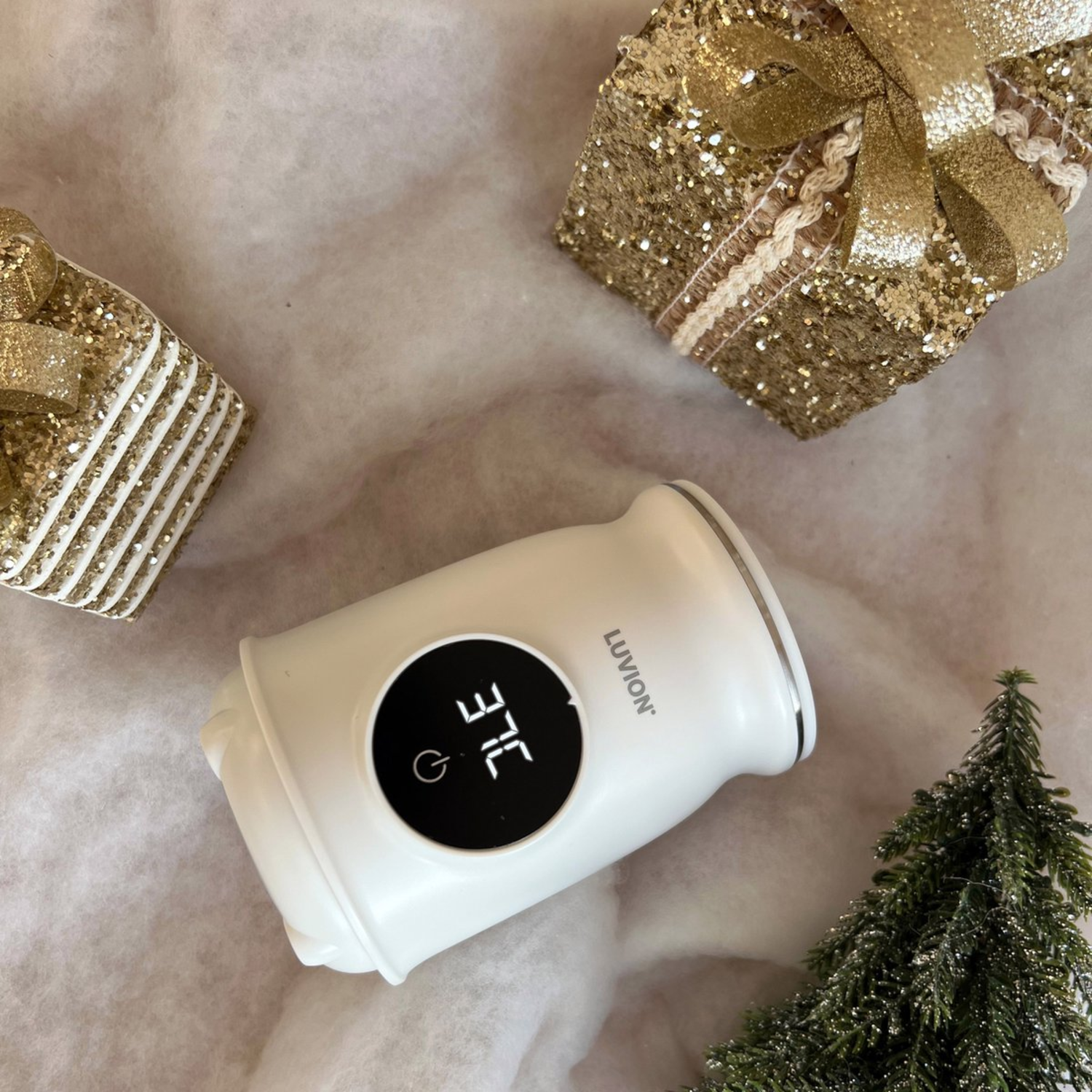 White device with digital display showing 37C, with gifts and a Christmas tree.