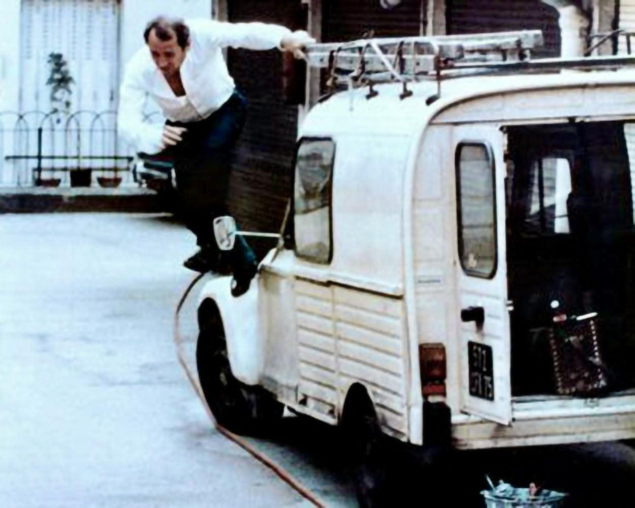 Mann springt von einem weißen Transporter mit Leiter. Szene aus einem Film.