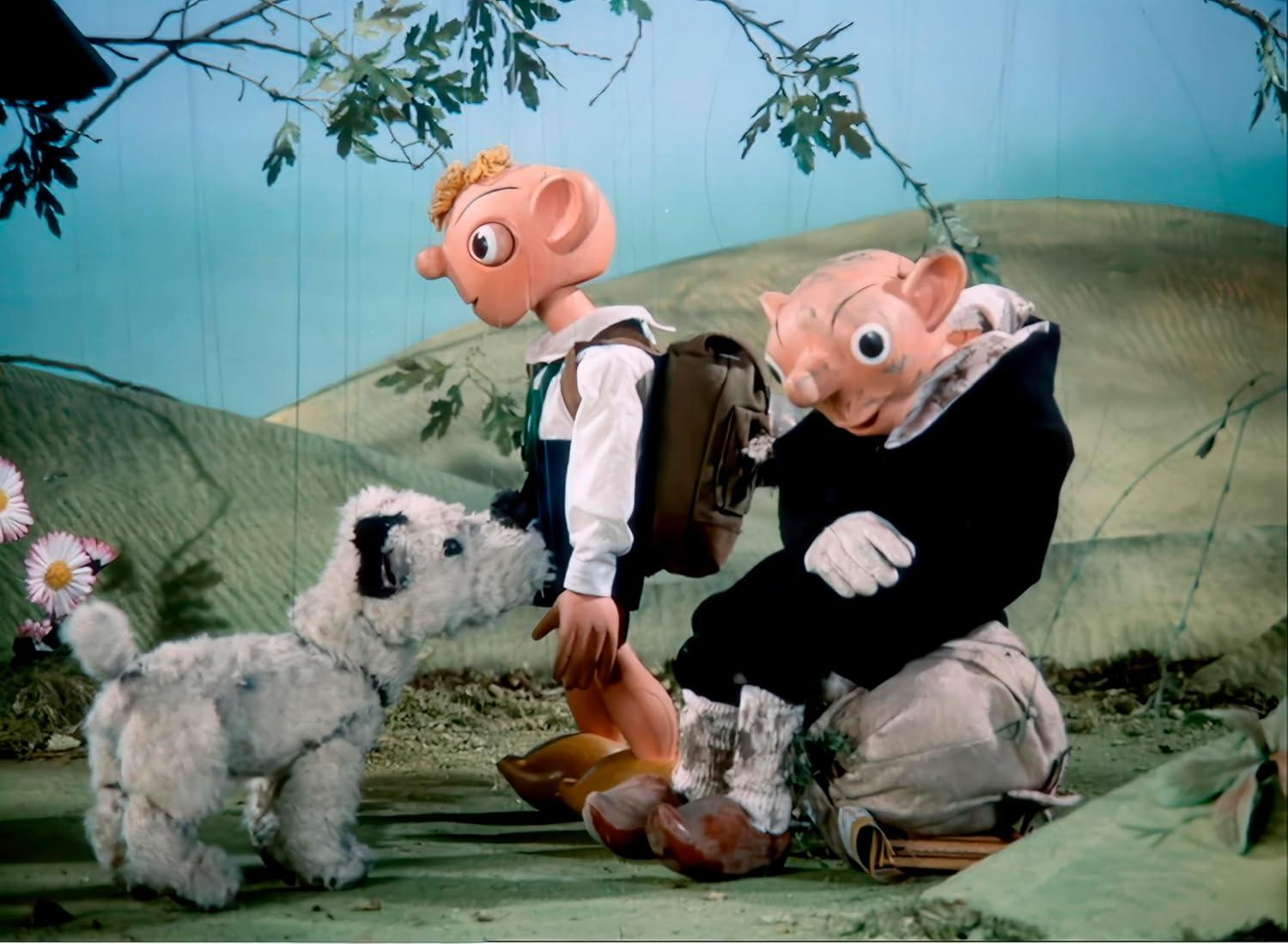 Zeichentrickfiguren in ländlicher Umgebung. Ein Hund, ein Junge und ein älterer Mann.