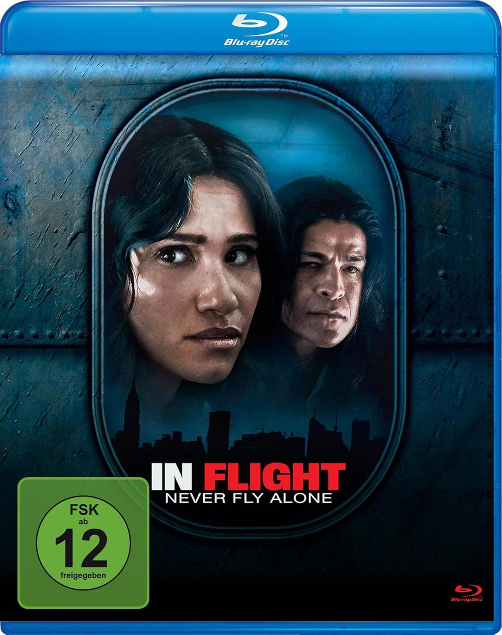 Blu-ray-Disc-Cover für 'In Flight'. Zwei Personen im Zentrum, darunter eine Stadtsilhouette.