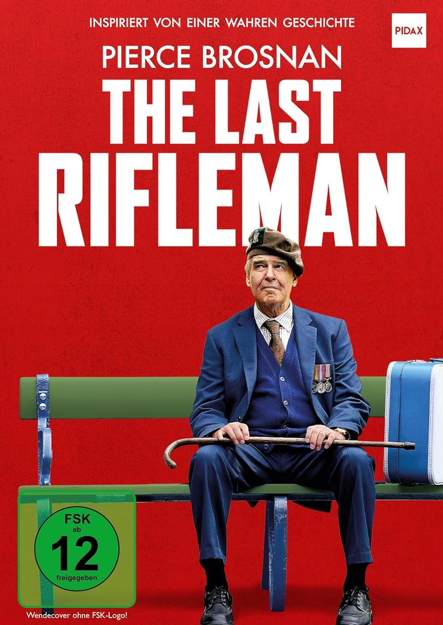 Filmplakat mit Pierce Brosnan, Text in Rot, grüner Badge, schwarzer Hintergrund.