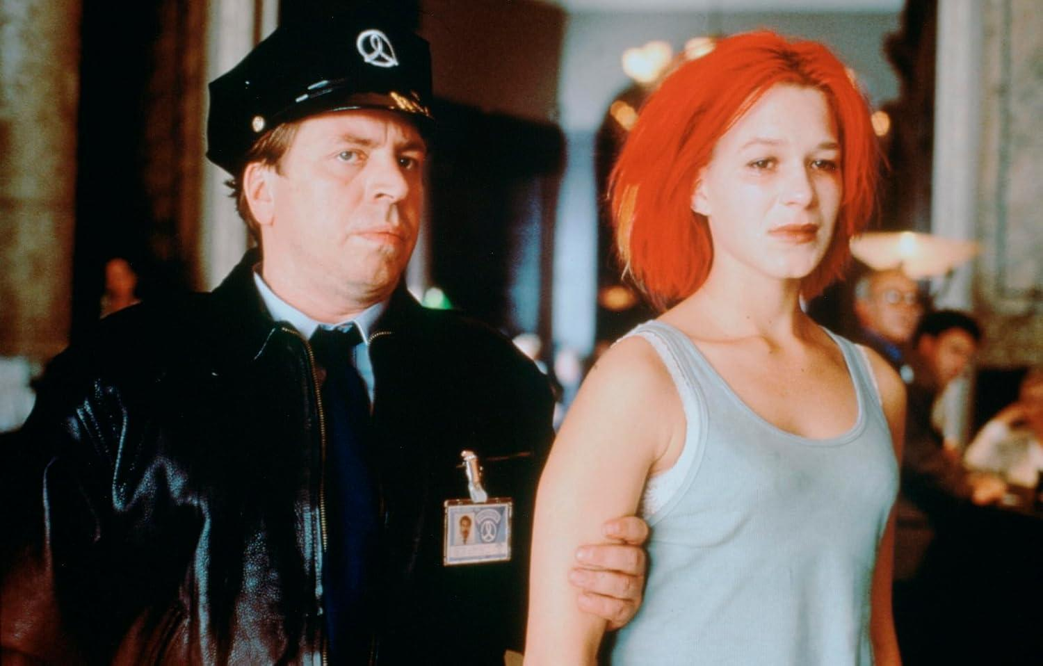 Ein Mann in Polizeiuniform hält eine Frau mit roten Haaren.