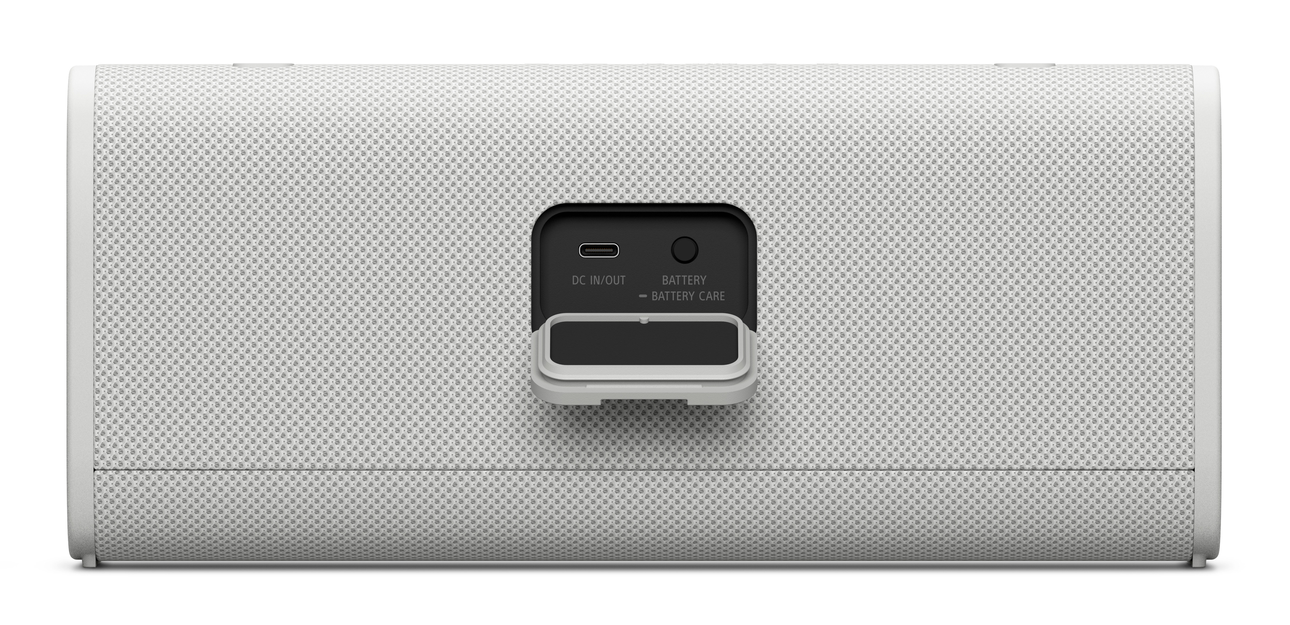 Tył głośnika: otwarta osłona portu, DC, bateria i okrągły przycisk.