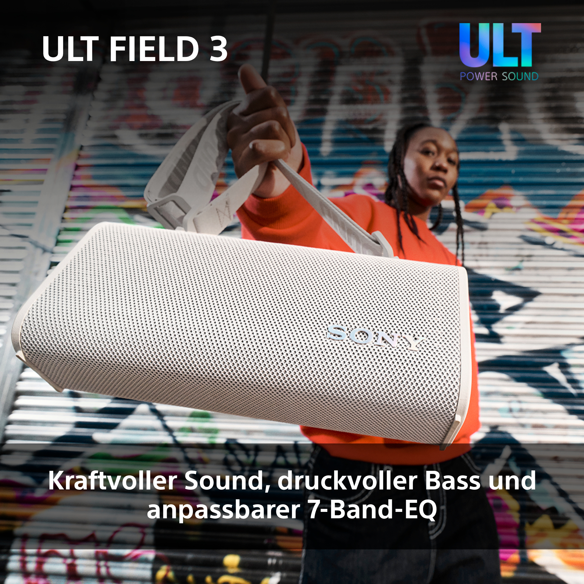 Weißer Sony ULT FIELD 3 Lautsprecher, gehalten von einer Person mit Graffiti-Hintergrund.