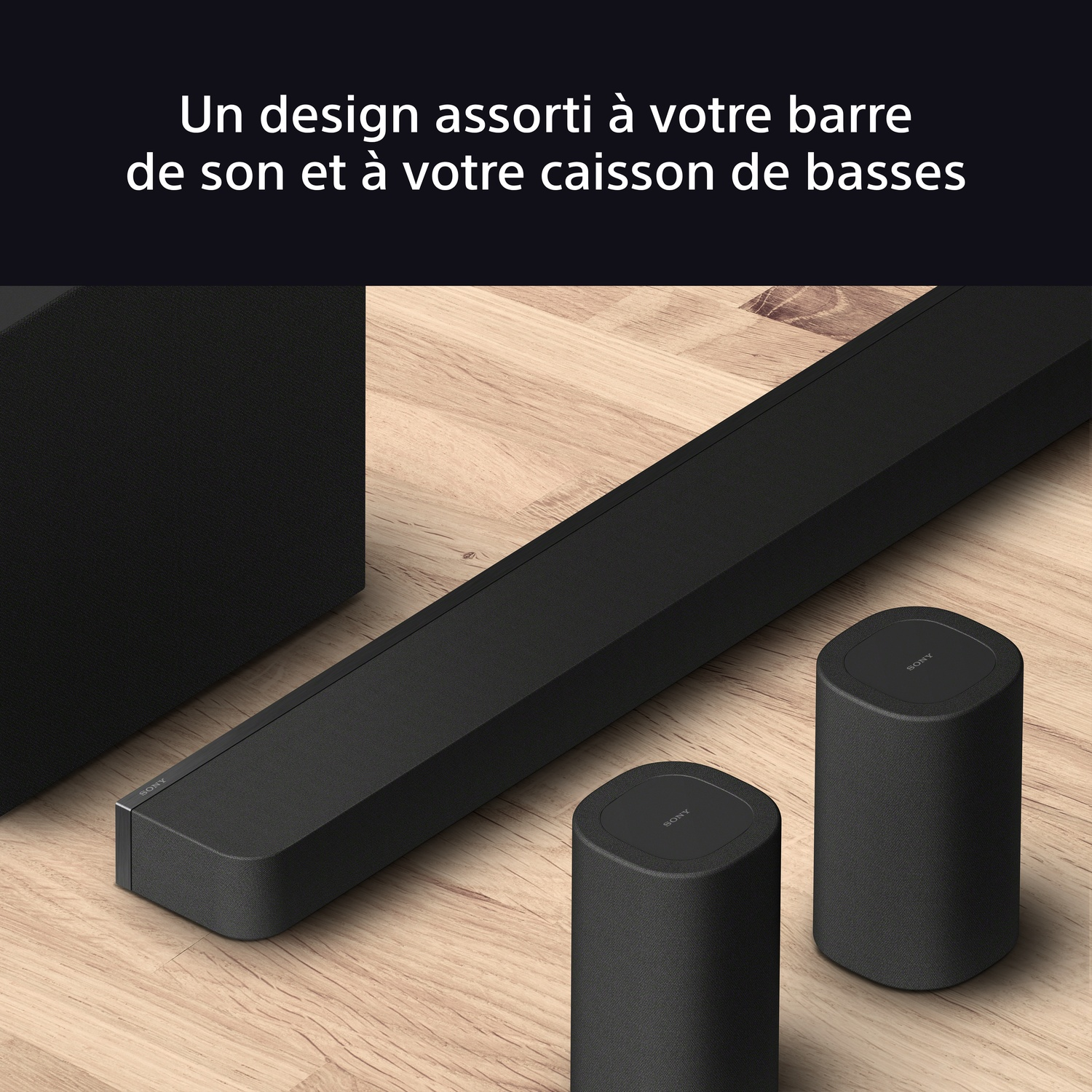 Une barre de son noire et deux enceintes assorties sur une surface en bois.