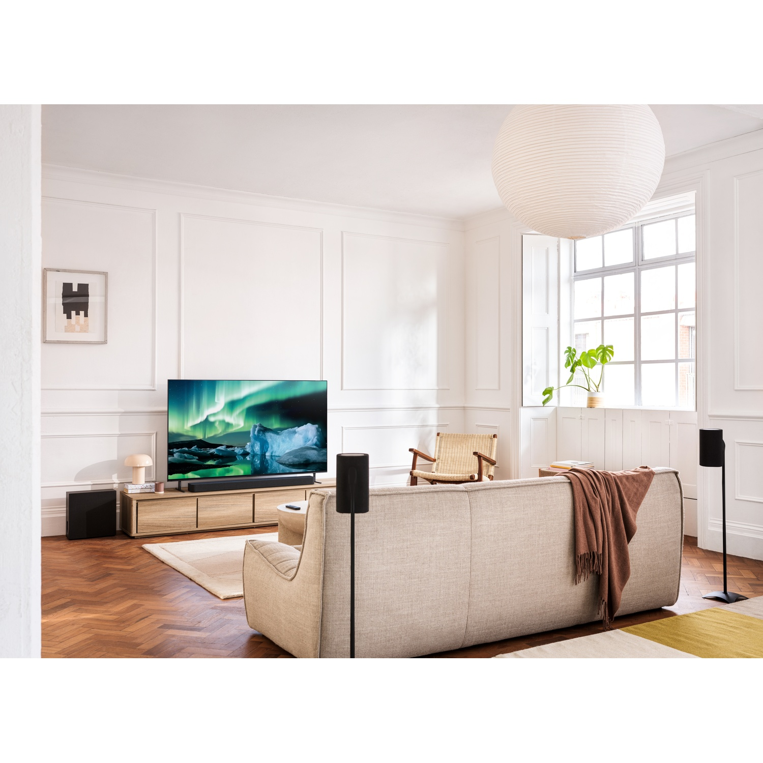 Une scène de salon avec une télévision, des enceintes et un canapé.