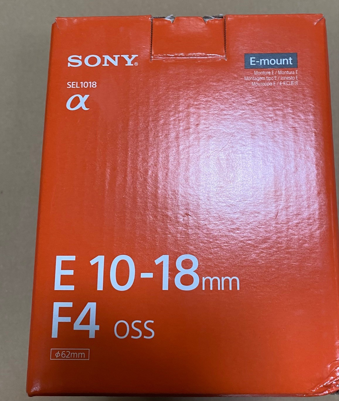 Pomarańczowe pudełko aparatu Sony z tekstem: E 10-18mm F4 OSS.