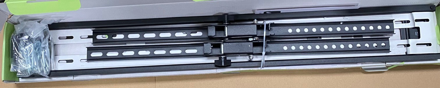 Srebrny mechanizm uchwytu ściennego TV ze śrubami w zielonym pudełku.