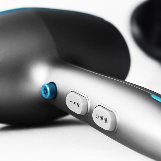 Zbliżenie suszarki do włosów z przyciskami i niebieskim przyciskiem z boku.