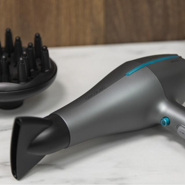 Szara suszarka do włosów Cecotec z nasadką dyfuzora i marmurowym tłem.
