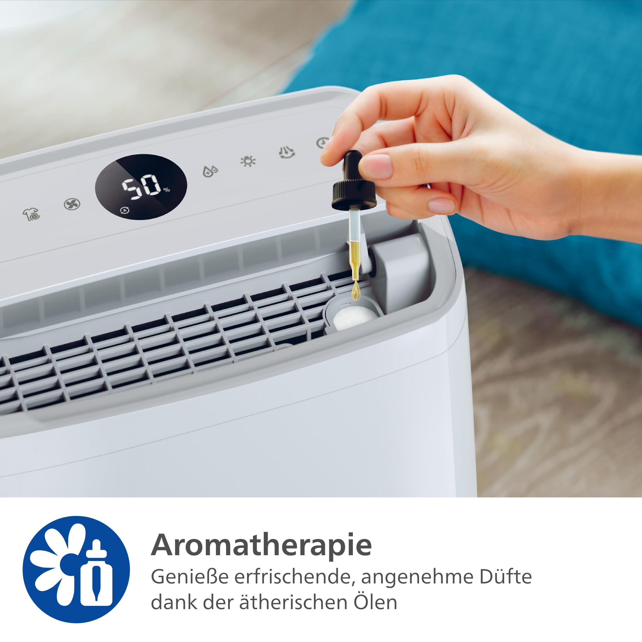 Eine Person fügt Tropfen von einer Pipette zu einem weißen Luftreiniger hinzu.