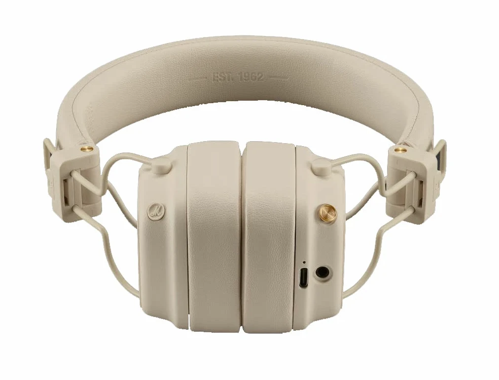 Kremowe słuchawki. Opaska z napisem 'EST. 1962'. Słuchawki są złożone.