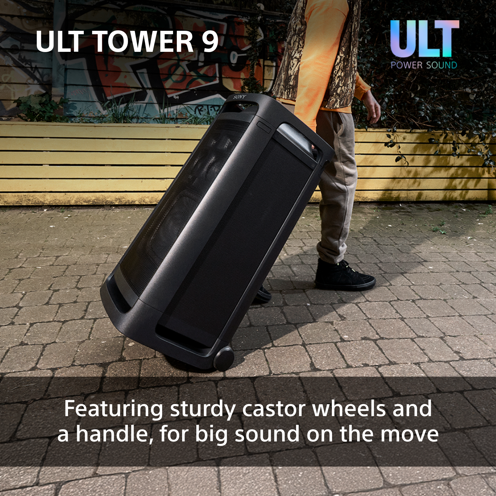 Una persona che tira un altoparlante nero con ruote. L'altoparlante ha il testo "ULT TOWER 9".