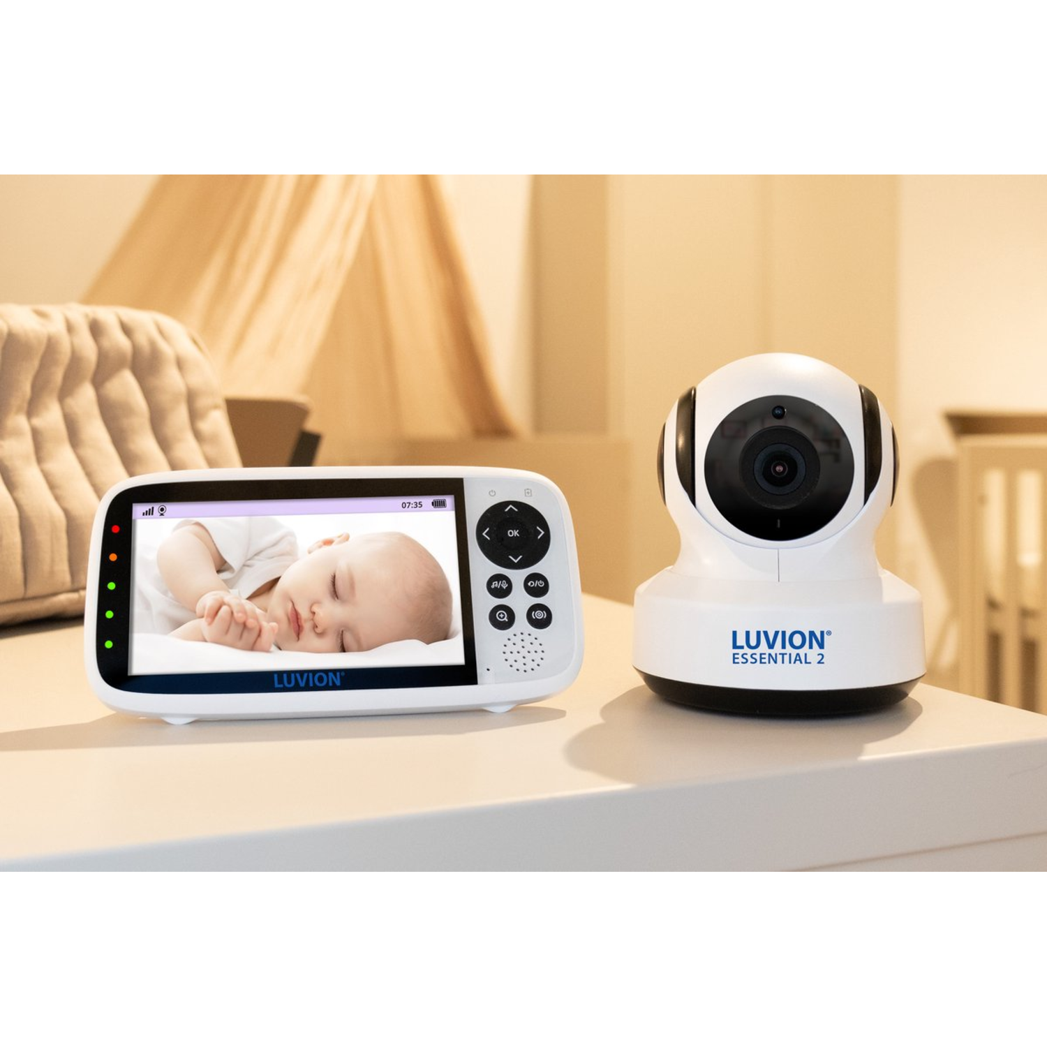 Baby monitor with a screen showing a baby, and a camera on a table.