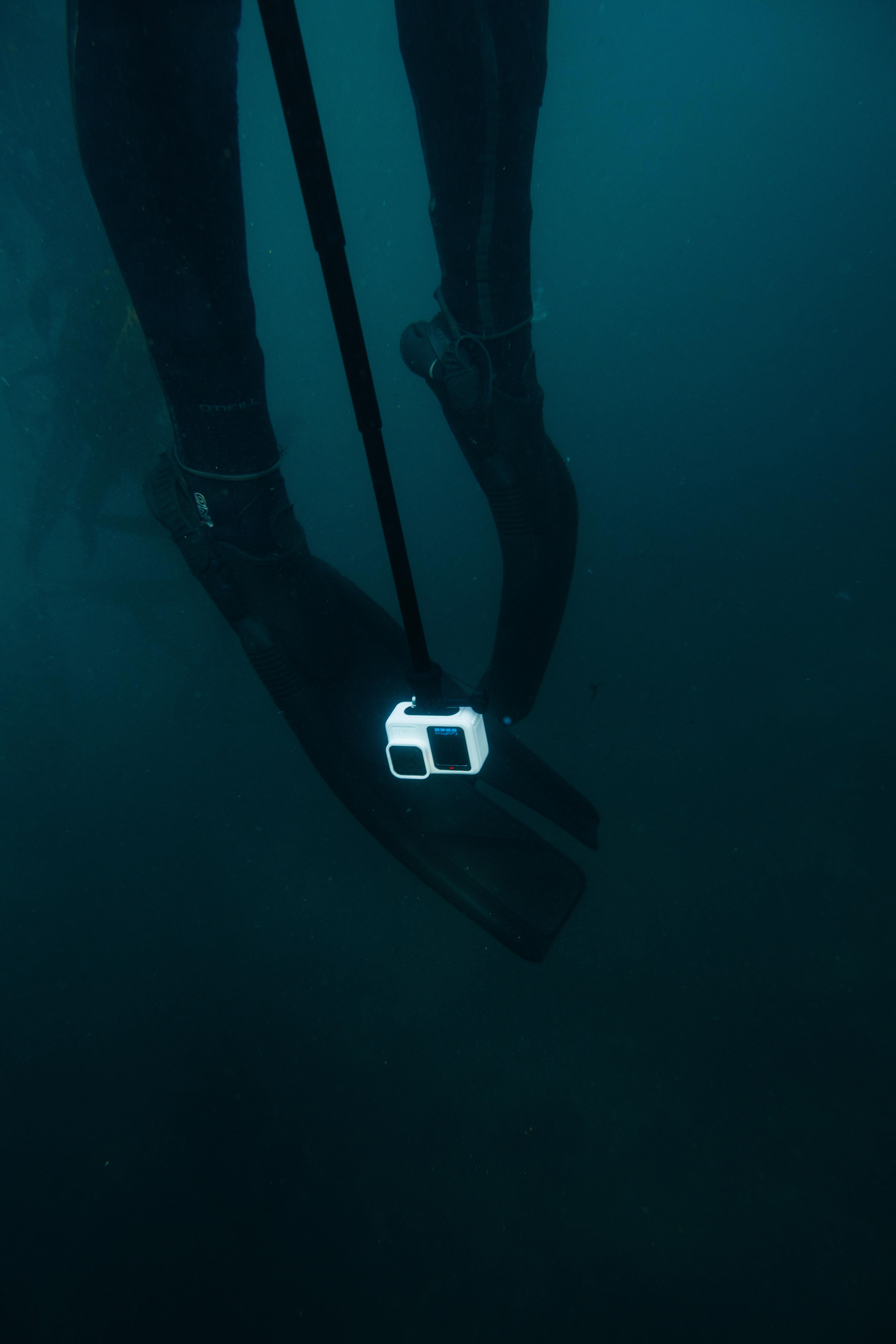 Unterwasseraufnahme von Flossen eines Tauchers mit befestigter Kamera.
