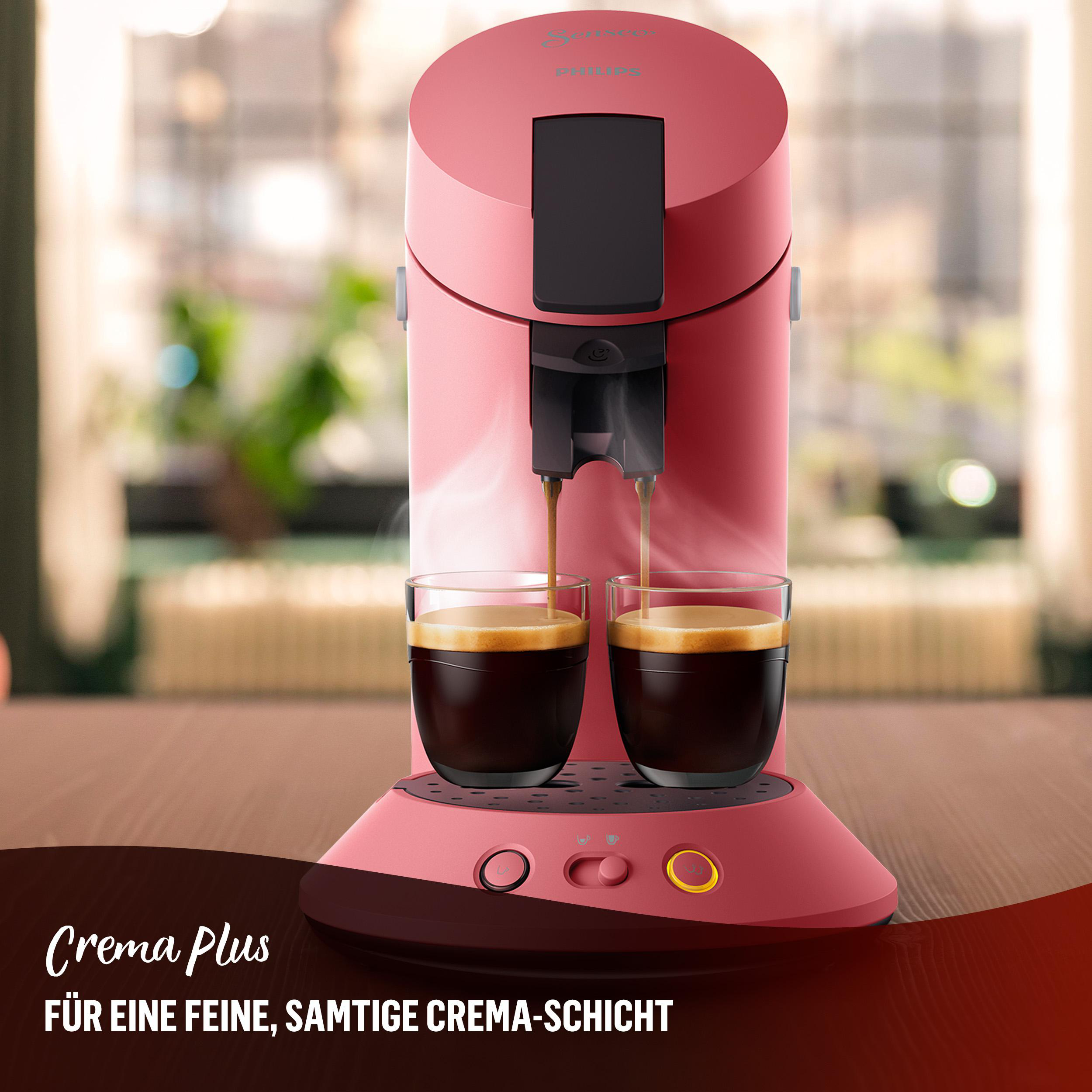 Rosafarbene Kaffeemaschine, die Kaffee in zwei Gläser ausgibt.