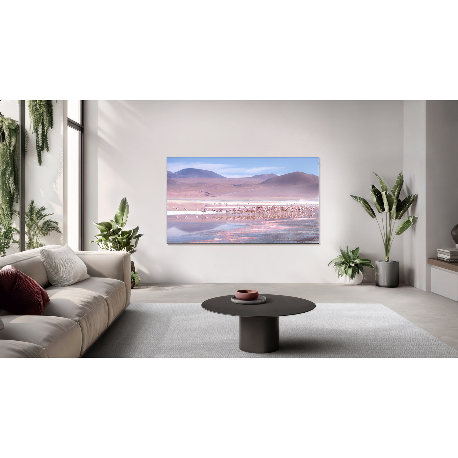 Interieur met grote tv, bank en tafel. De tv toont een landschap met roze water.