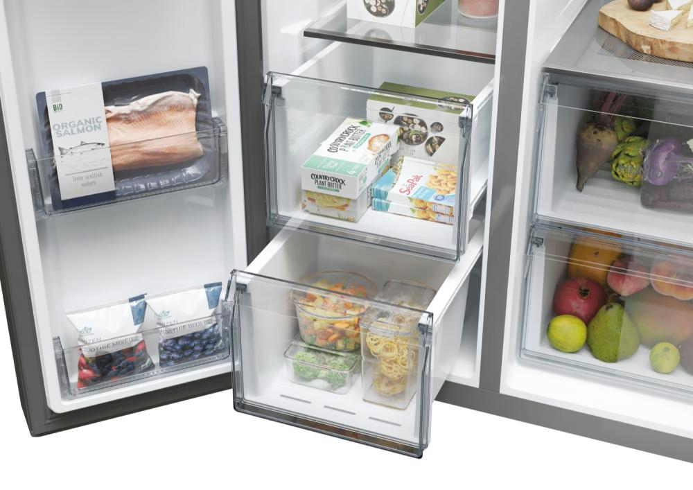 Offener Kühlschrank mit Schubladen voller Lebensmittel.