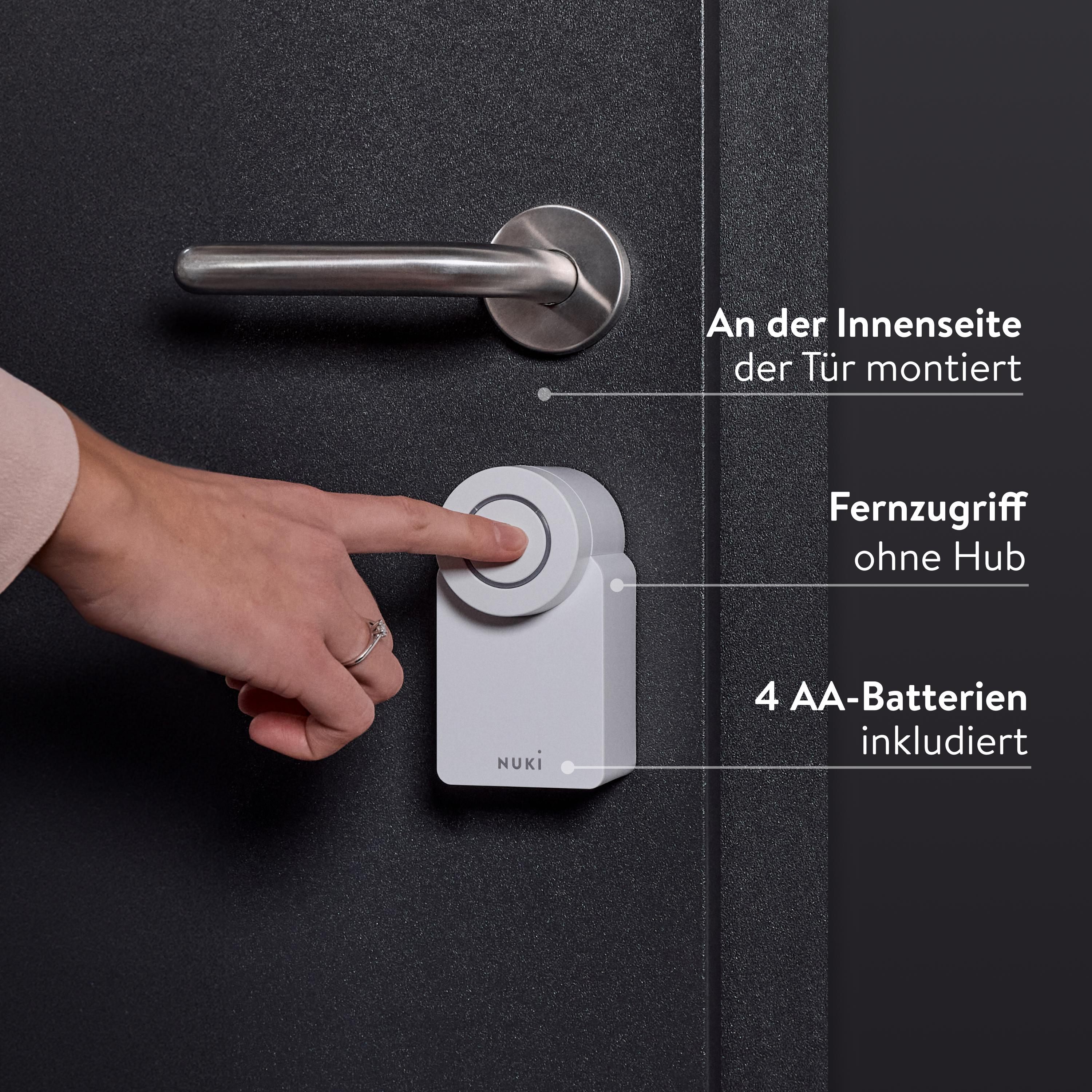 Eine Hand drückt einen Knopf auf einem weißen Smart Lock an einer schwarzen Tür.