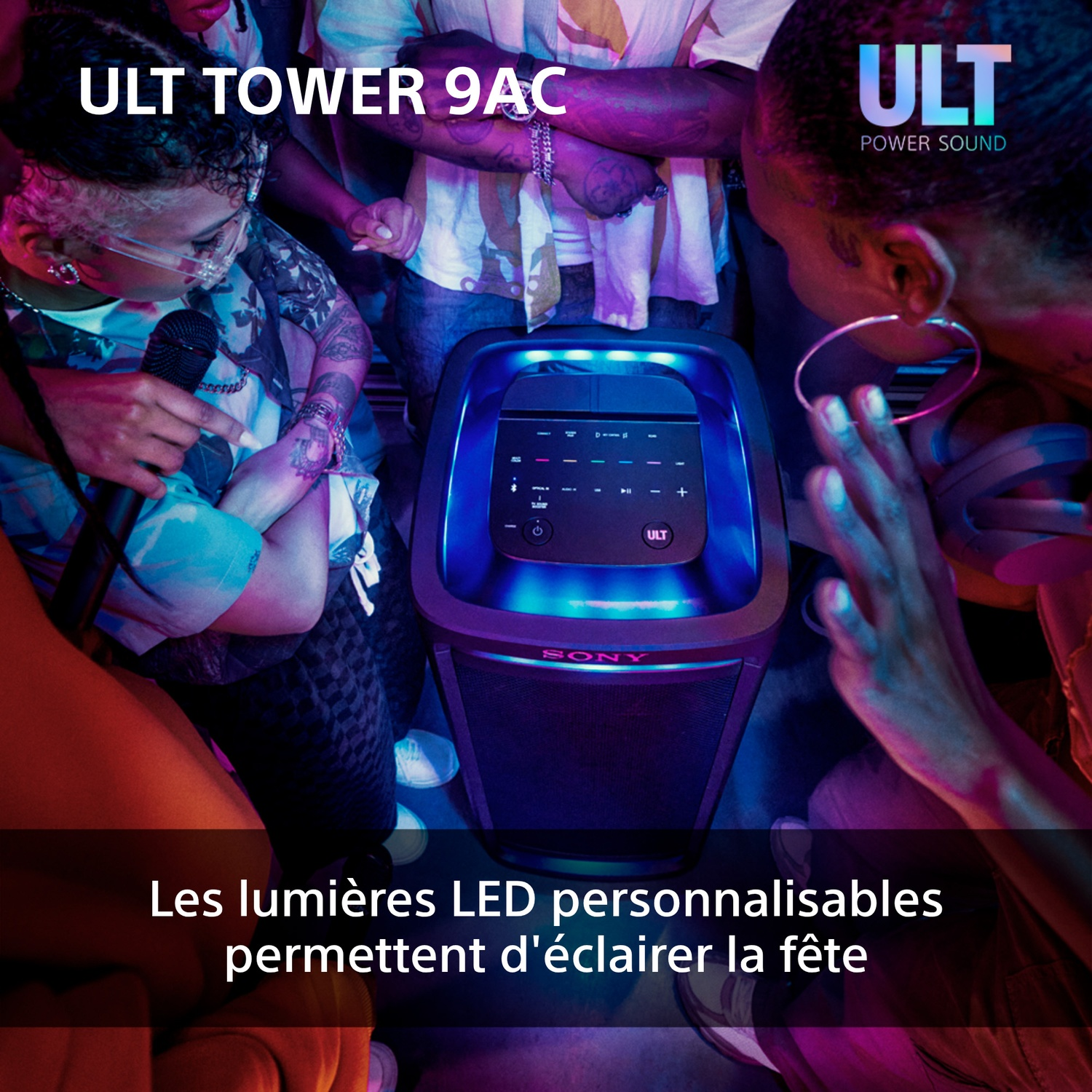 Des gens dansant autour d'un haut-parleur noir avec des lumières bleues, les mots 'ULT TOWER 9AC' sont visibles.