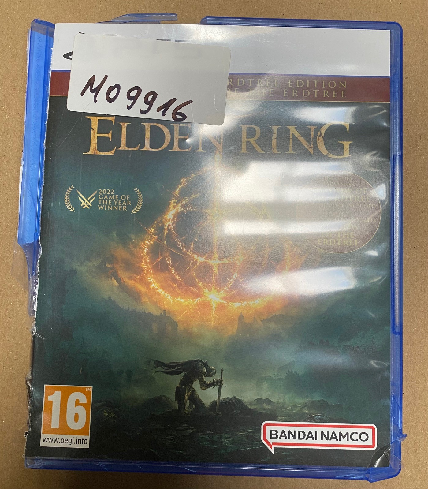 Pudełko gry Elden Ring, zapieczętowane w plastiku. Okładka ma rycerza i tekst.