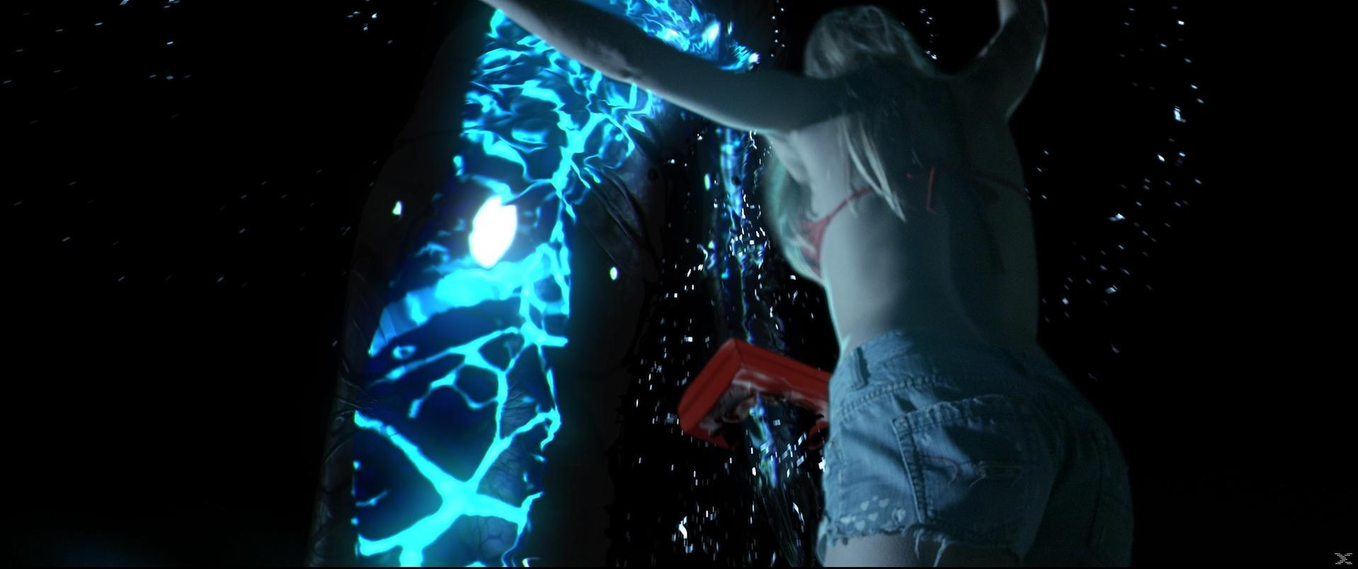 Eine Frau in Bikini-Shorts steht, Wasser spritzt in der Nähe eines blauen Energieeffekts.