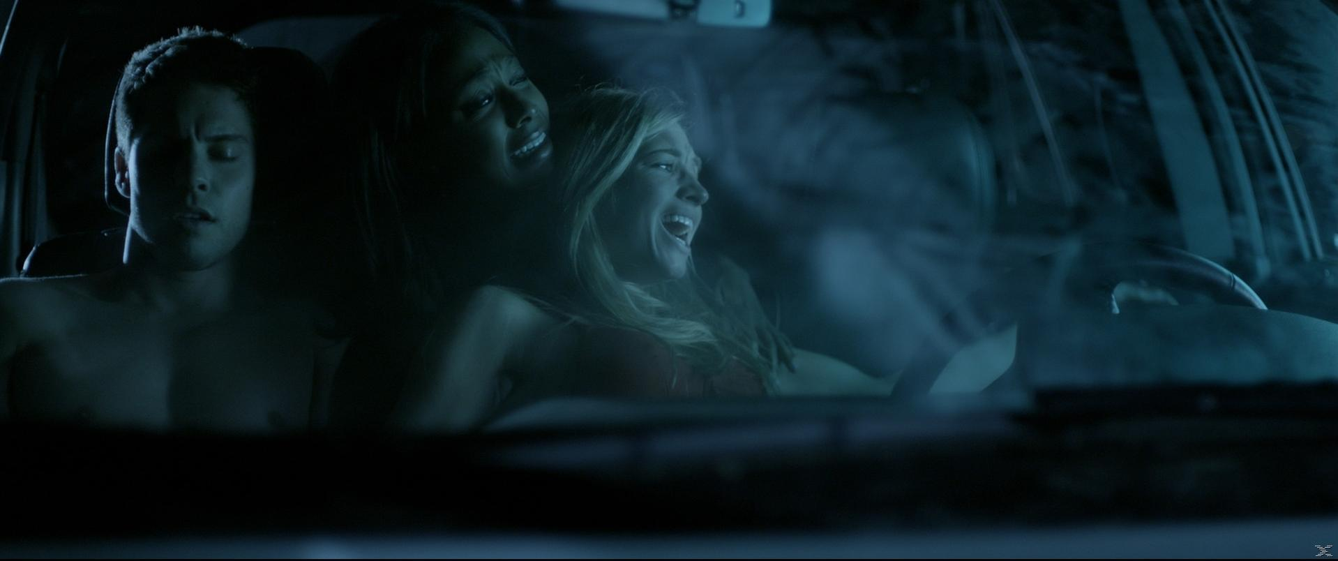 Drei Personen in einem Auto bei Nacht. Ein Mann und zwei Frauen. Der Innenraum des Autos ist sichtbar.