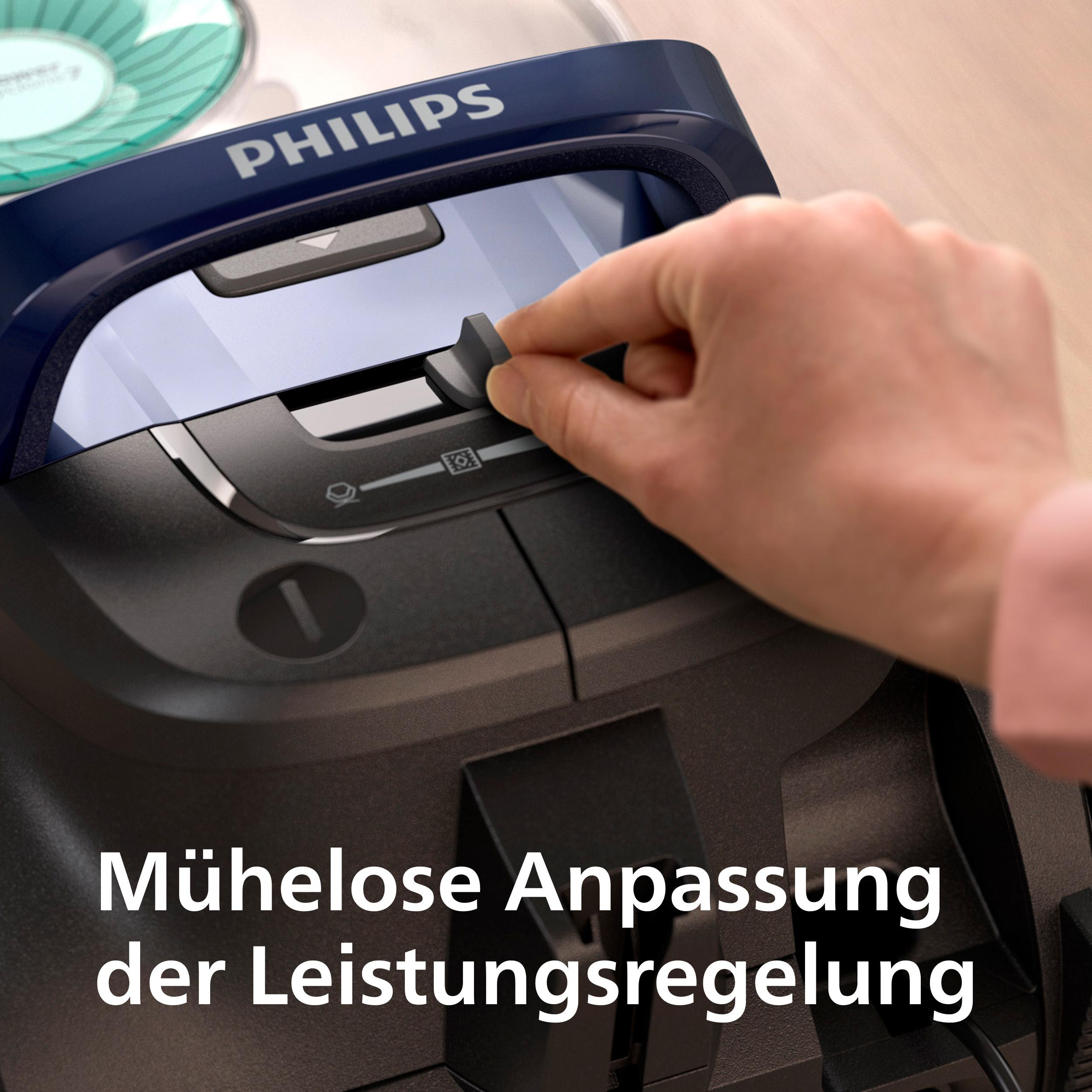 Eine Hand stellt die Leistungsregelung an einem schwarz-blauen Staubsauger ein.