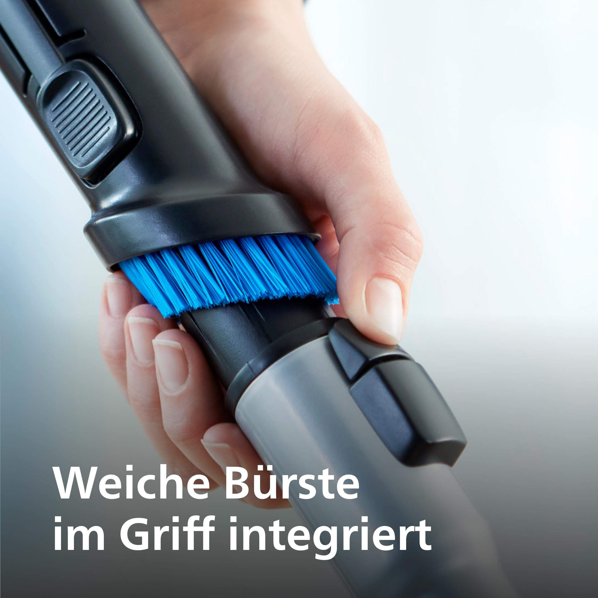 Nahaufnahme des Staubsaugergriffs. Blaue Bürstenbefestigung sichtbar. Text: 'Weiche Bürste'.