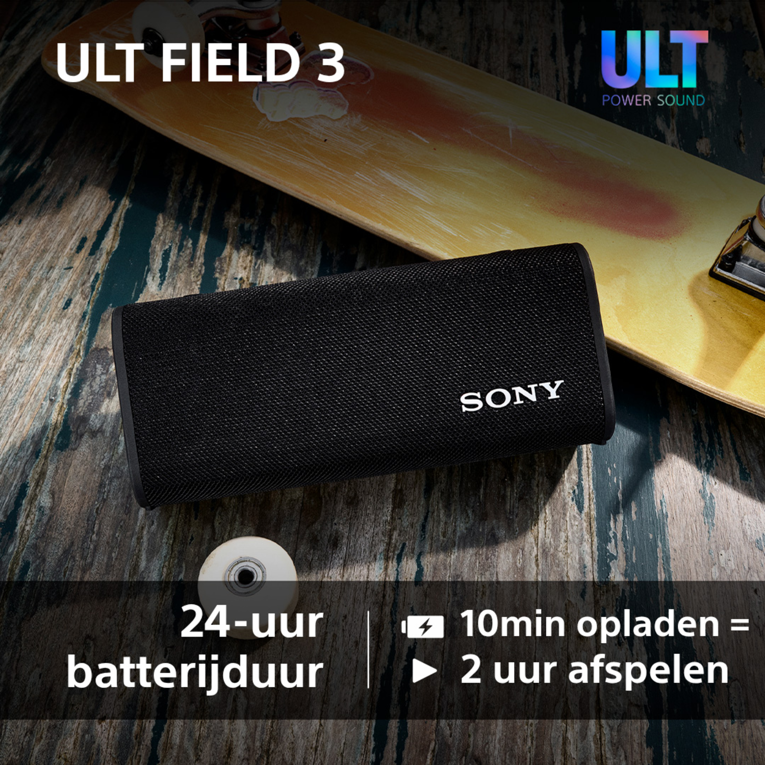 Black speaker on wood with a skateboard. Text says 24-uur batterijduur, 10min opladen = 2 uur afspelen