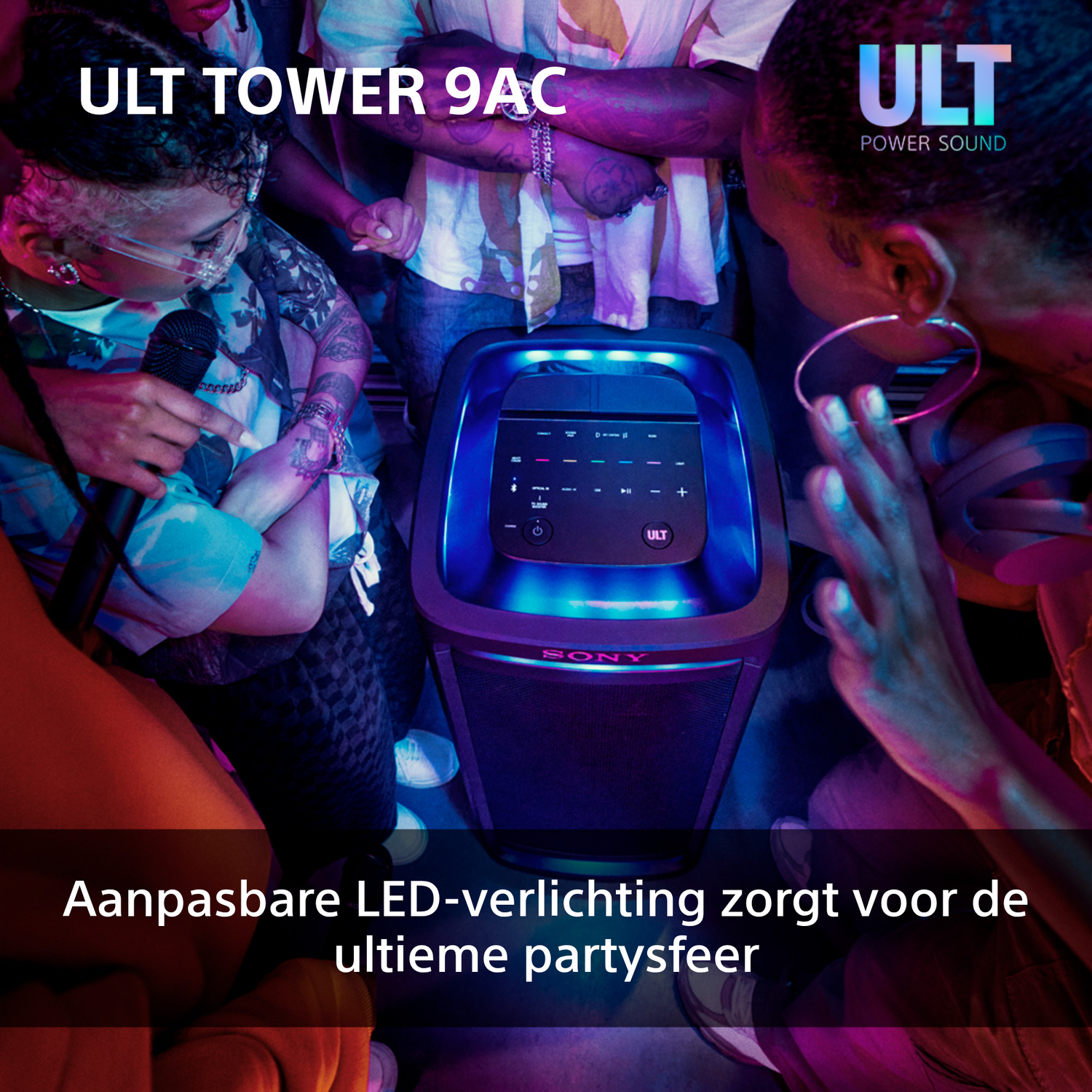A speaker with blue light and some people around it.