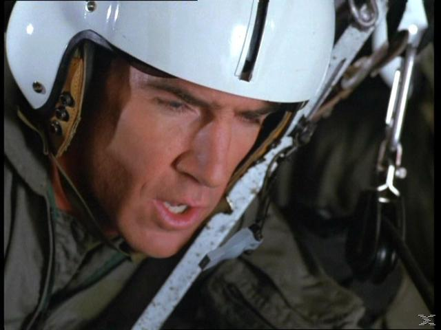 Ein Mann in weißem Helm und Militärkleidung blickt nach unten und links.