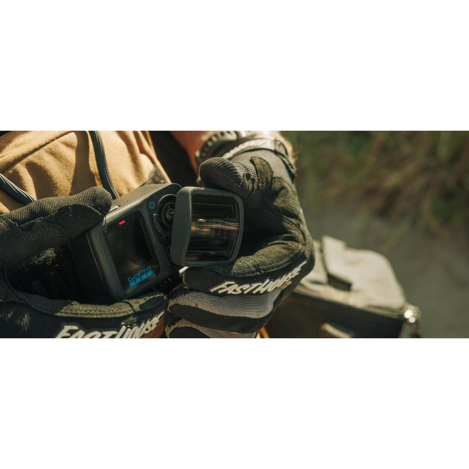 Persoon die een GoPro-camera met handschoenen vasthoudt, close-up.