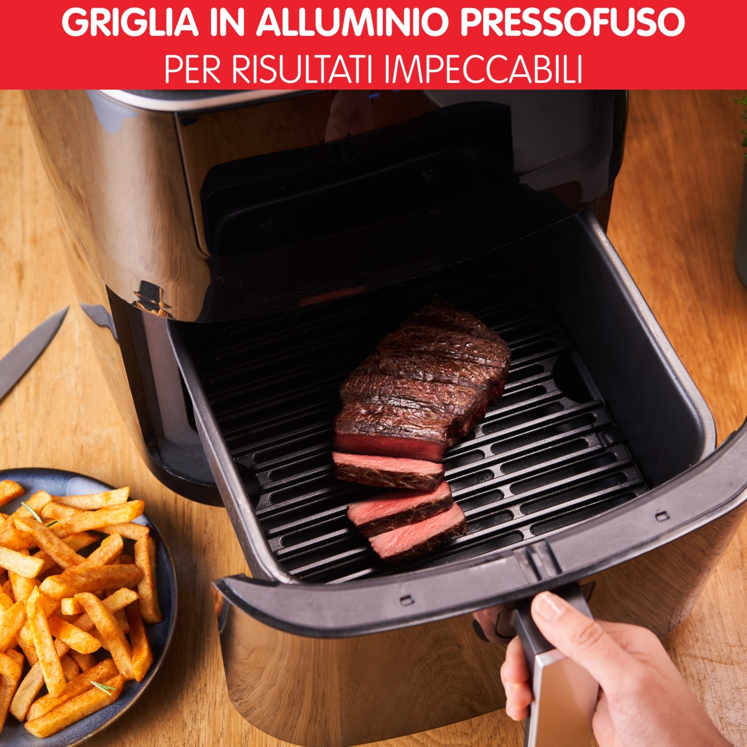 Una friggitrice ad aria che mostra bistecca e patatine fritte cotte all'interno, su una superficie di legno.
