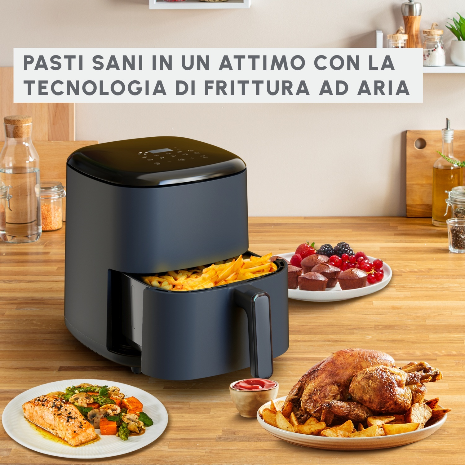 Friggitrice ad aria con cibo all'interno e altri piatti di cibo, su un tavolo di legno.