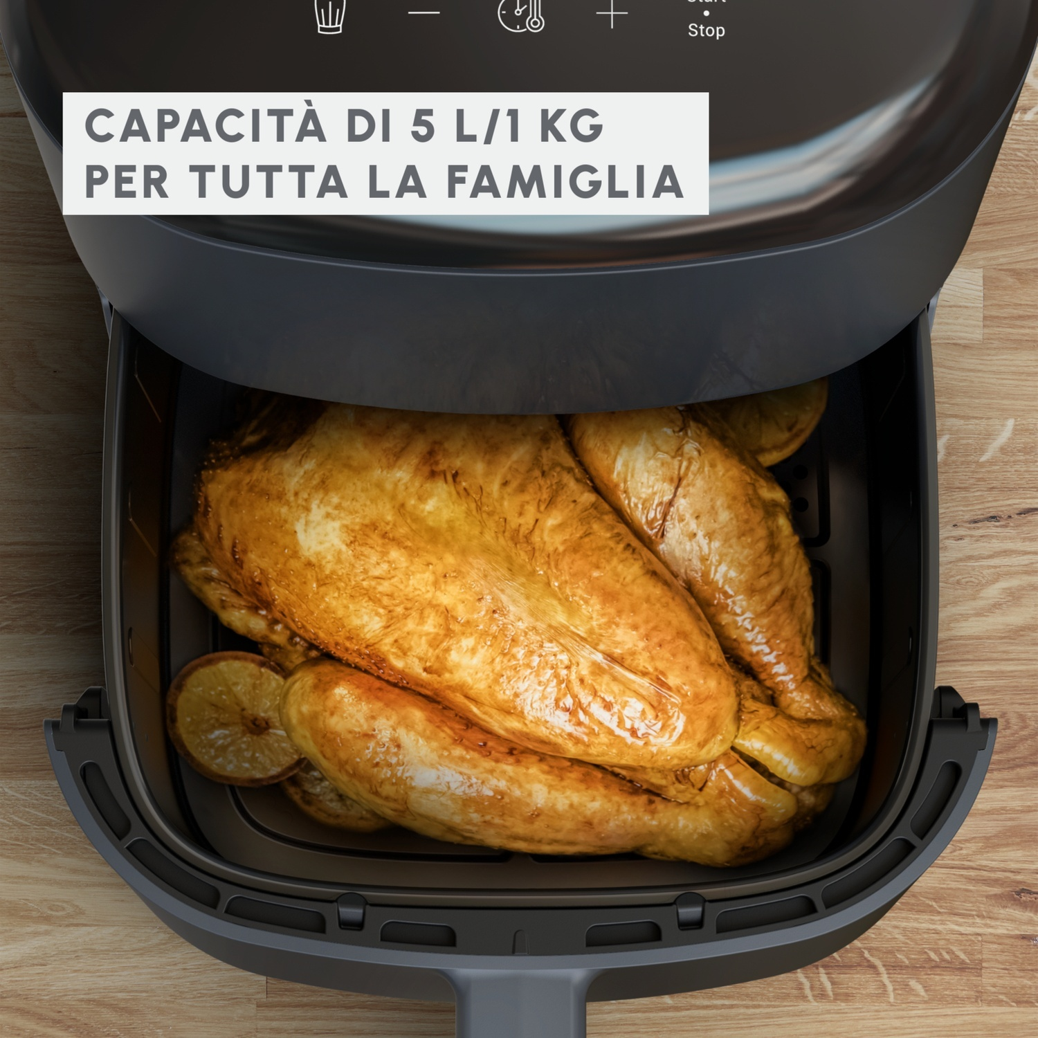 Pollo cotto in una friggitrice ad aria. Superficie in legno. Coperchio aperto.