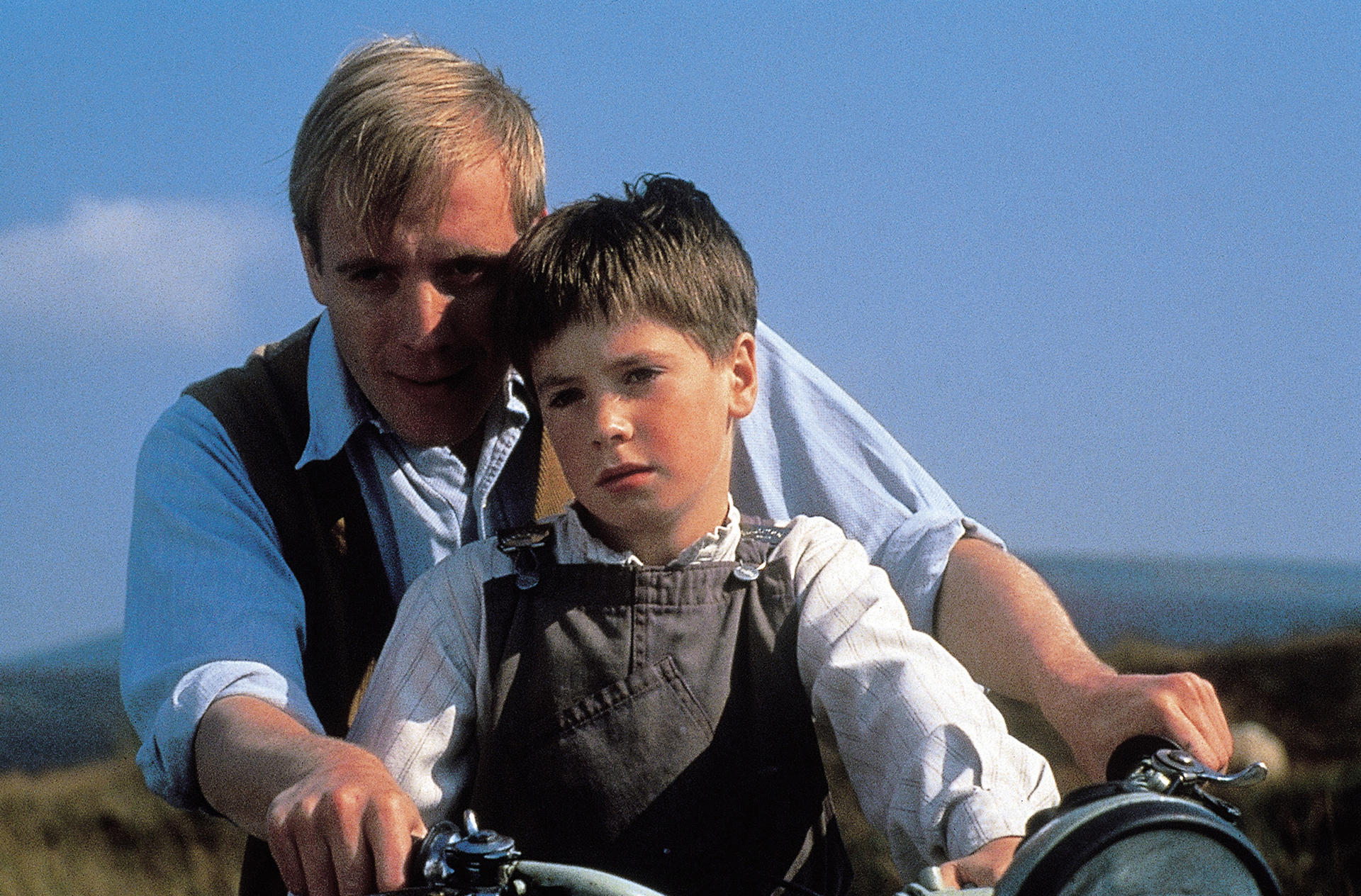 Mann bringt einem Jungen Motorradfahren bei.