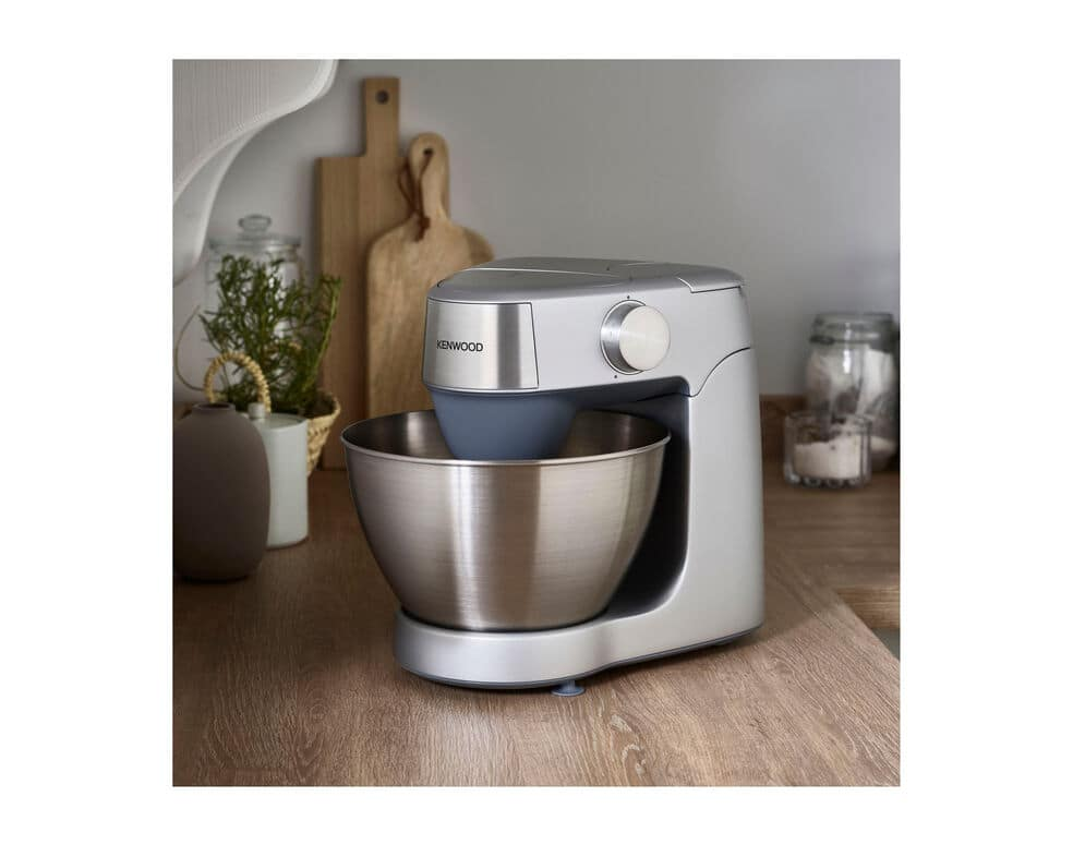 Ezüst Kenwood konyhai mixer egy fa pulton. Rozsdamentes acél tál az előtérben.
