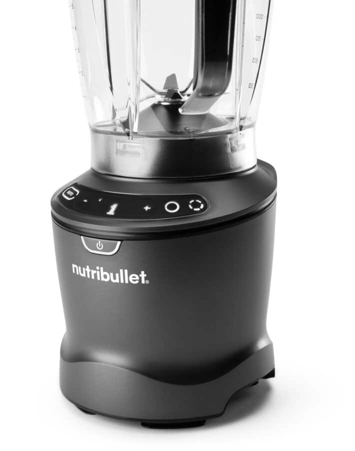 Egy Nutribullet turmixgép, sötétszürke, a vezérlőgombok az alján. Közelről van fotózva.