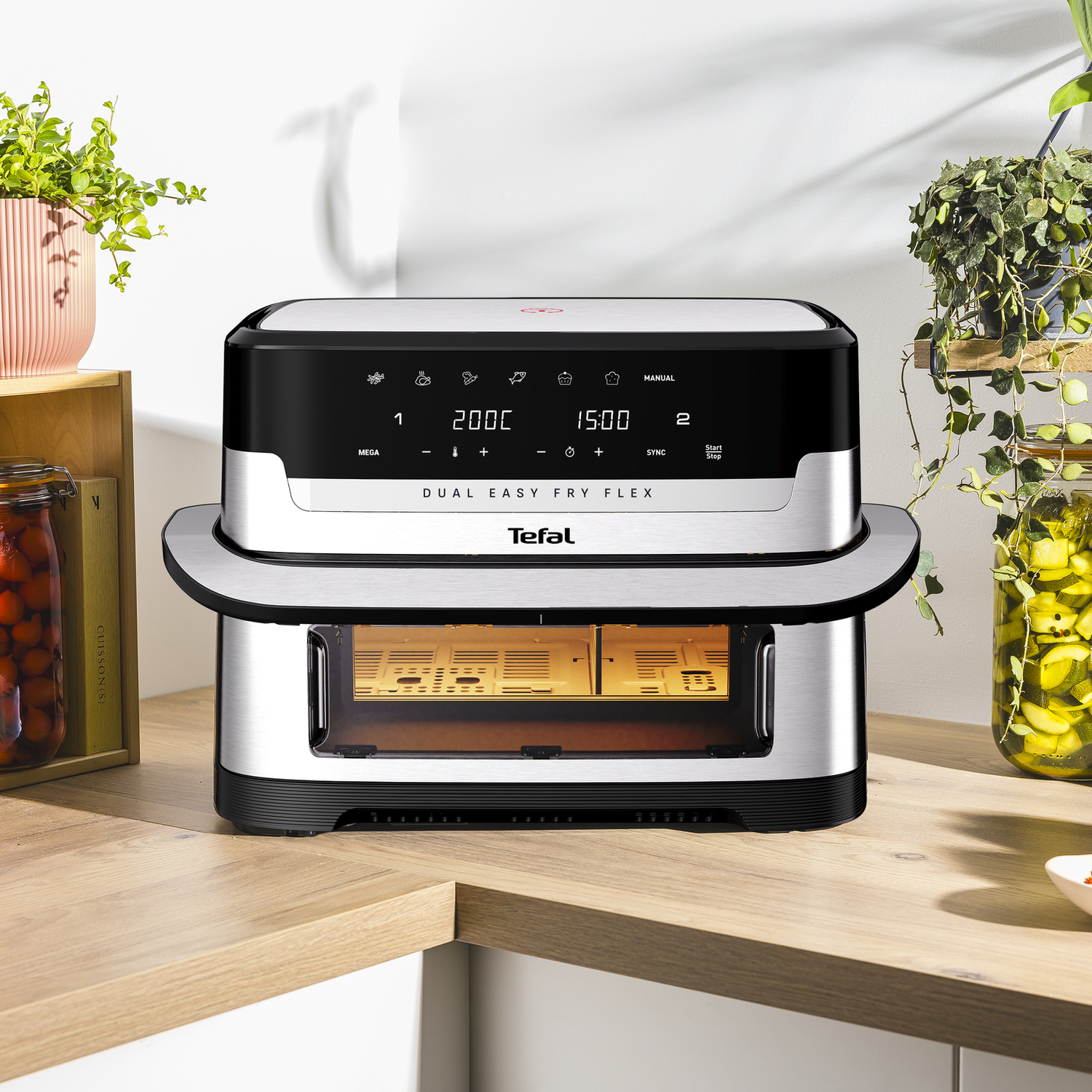 Dual air fryer. Black and silver. Food inside. White background. Plants. Text: DUAL EASY FRY FLEX.