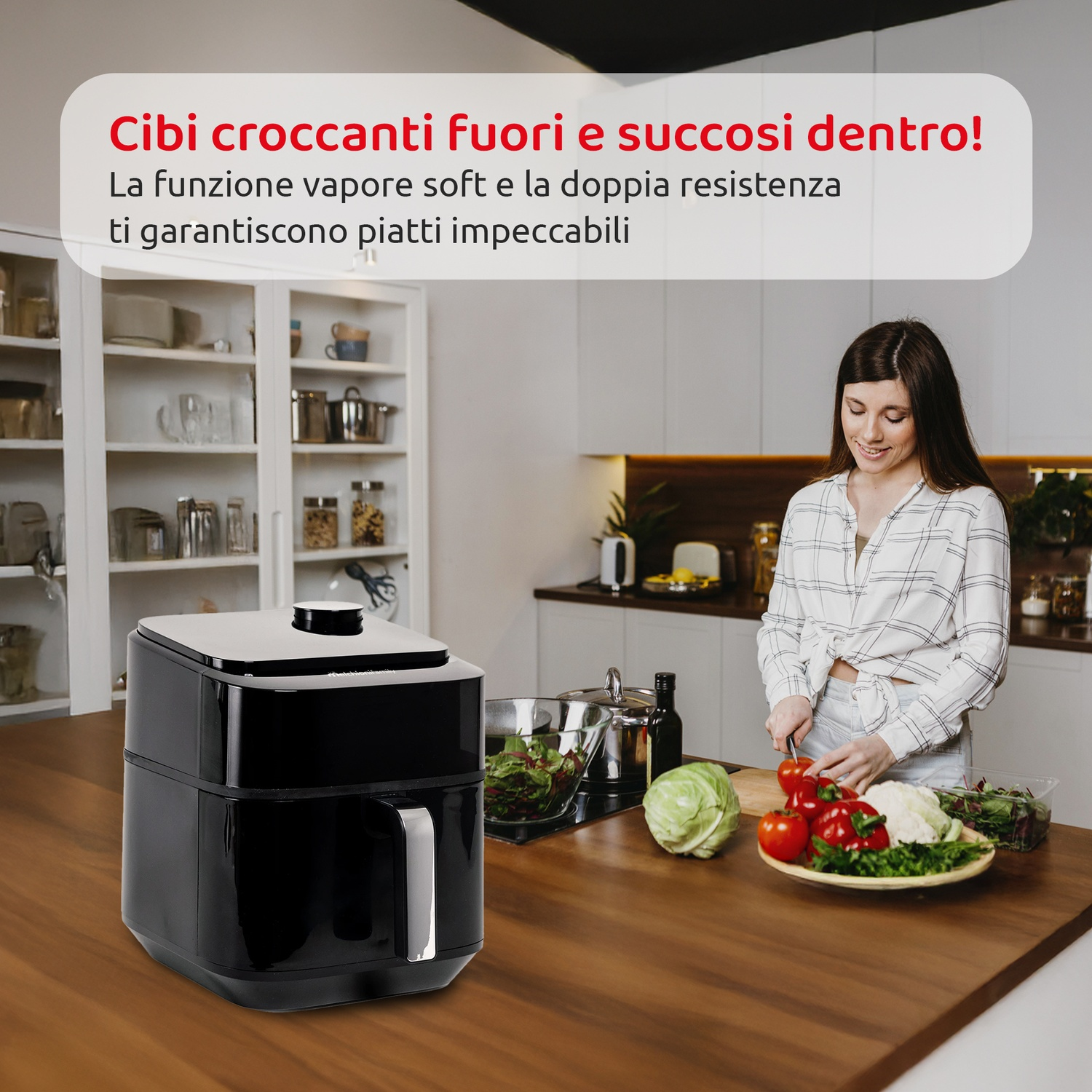 Una friggitrice ad aria nera su un piano di lavoro in legno, donna prepara cibo in cucina.