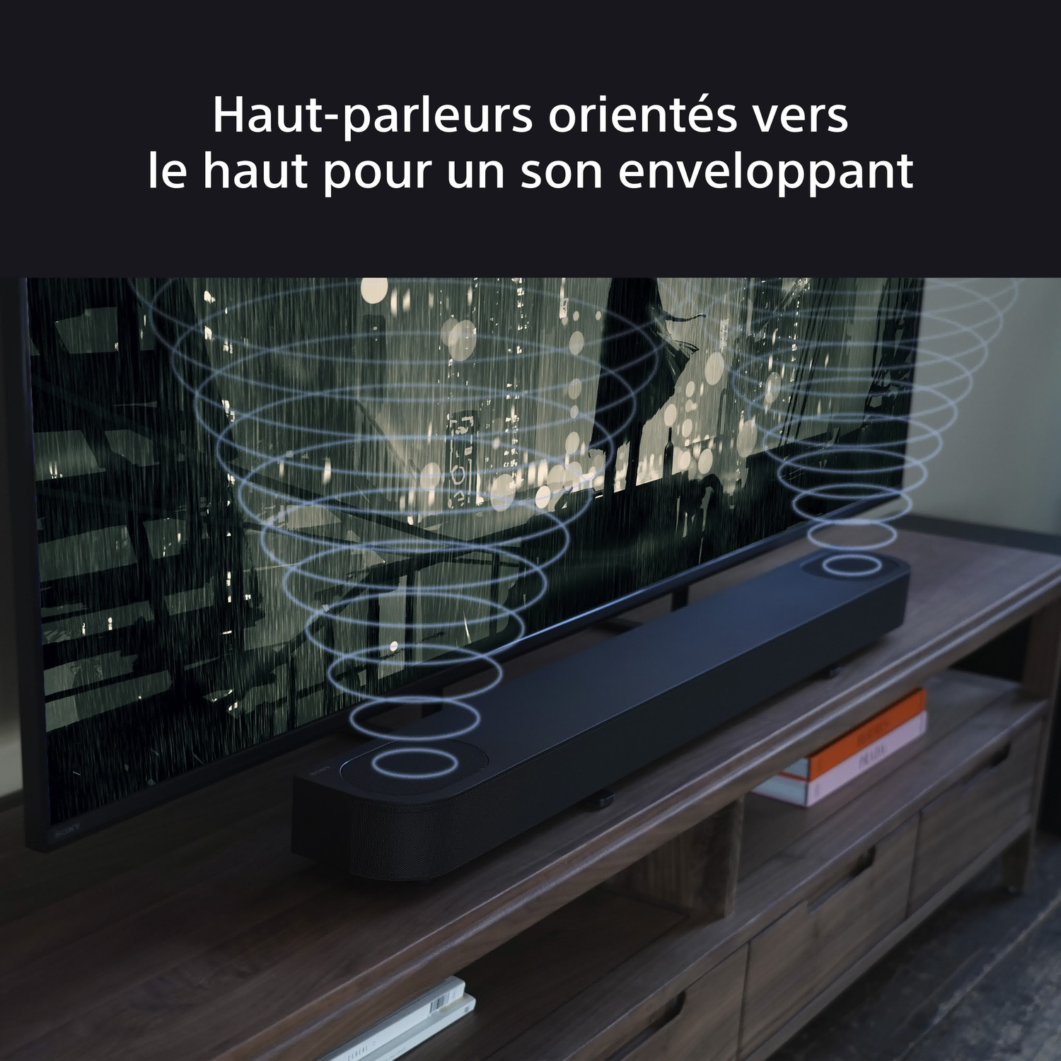 Une barre de son noire sur un meuble en bois, avec un paysage urbain en arrière-plan.