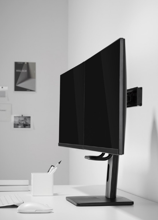 Két fekete számítógép-monitor egy asztalon, fehér egérrel és ceruzatartóval.
