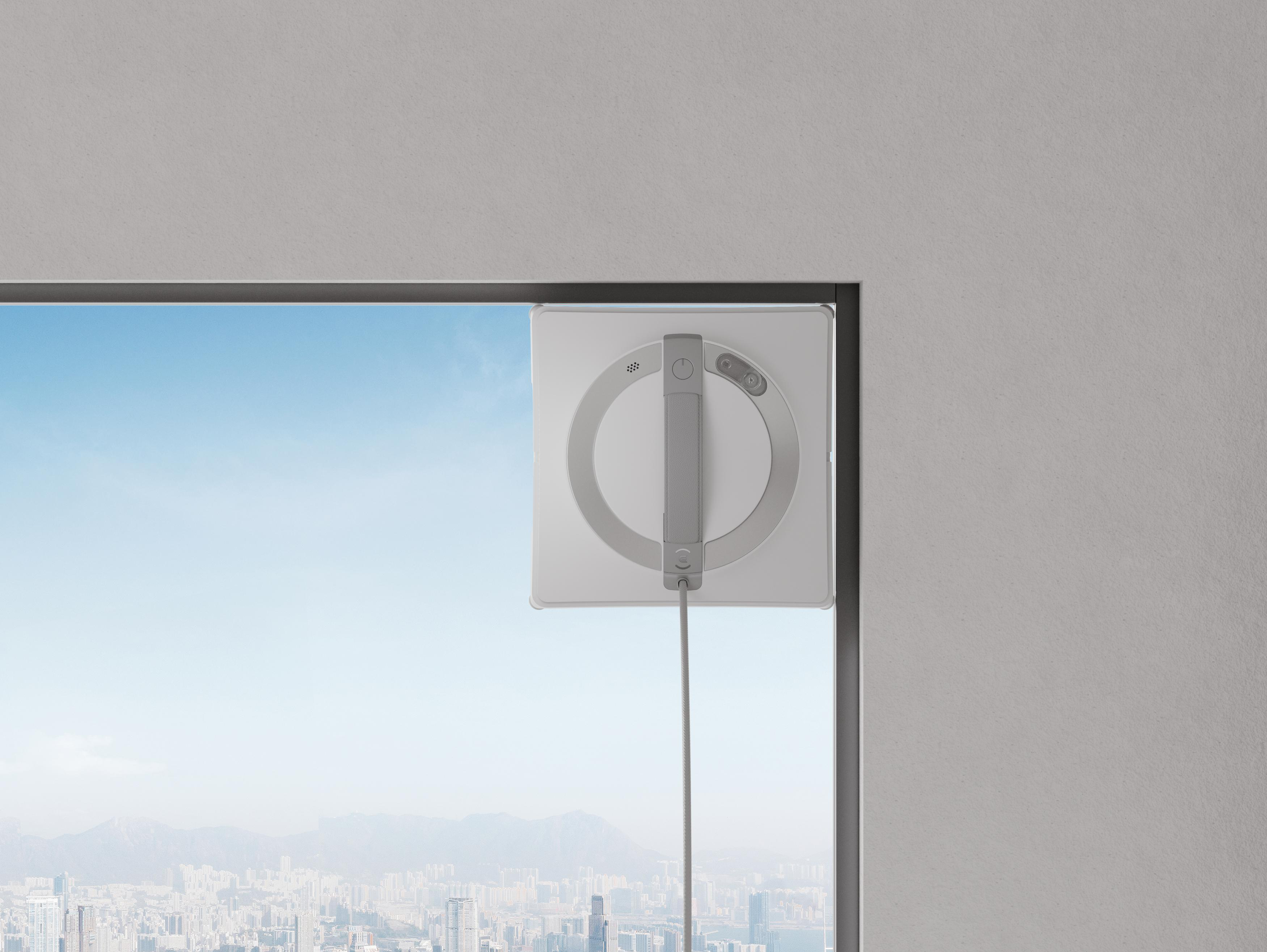 Fensterputzer an einem Fenster mit Stadtblick und blauem Himmel.