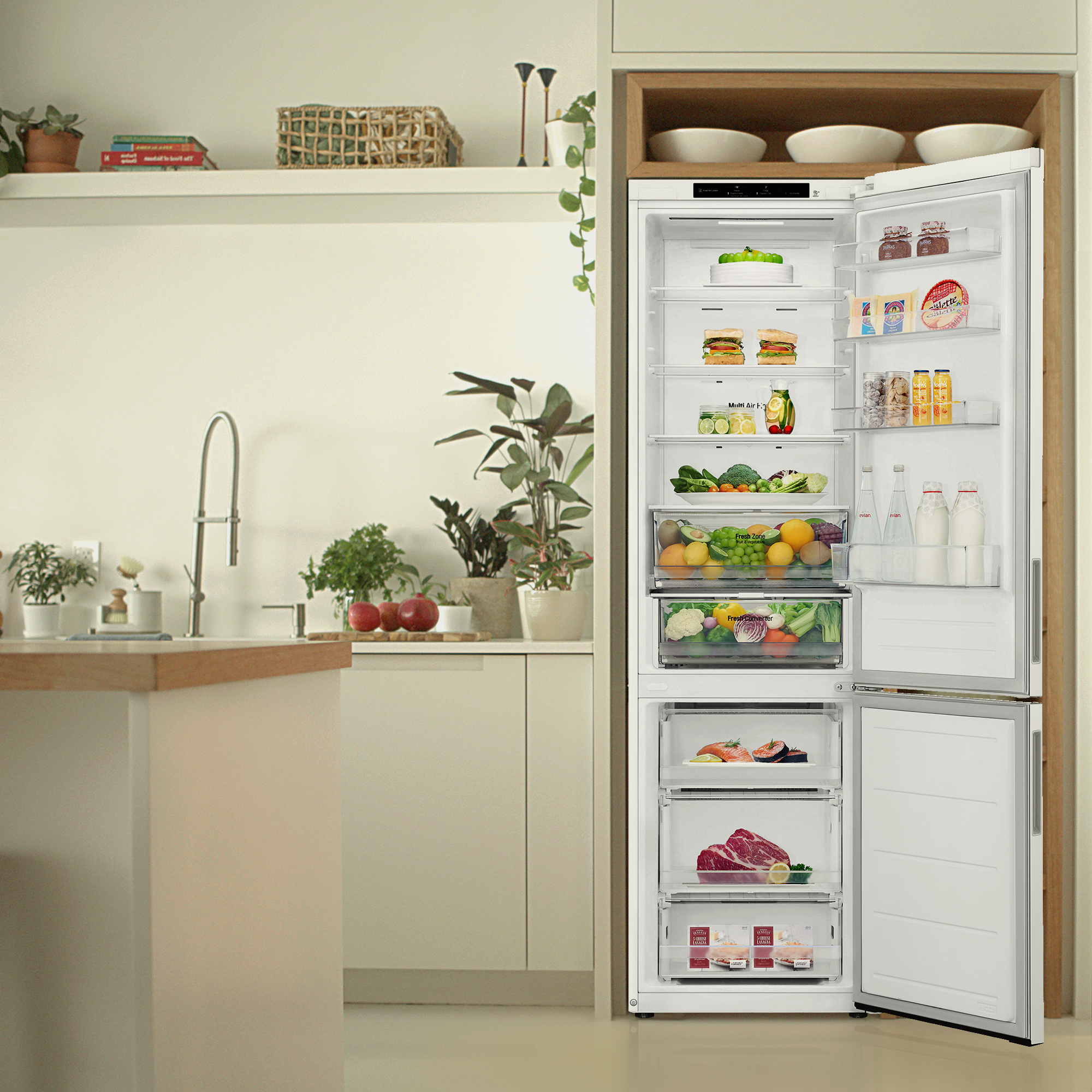 Un refrigerador blanco con las puertas abiertas, lleno de comestibles, contra un fondo de cocina brillante.