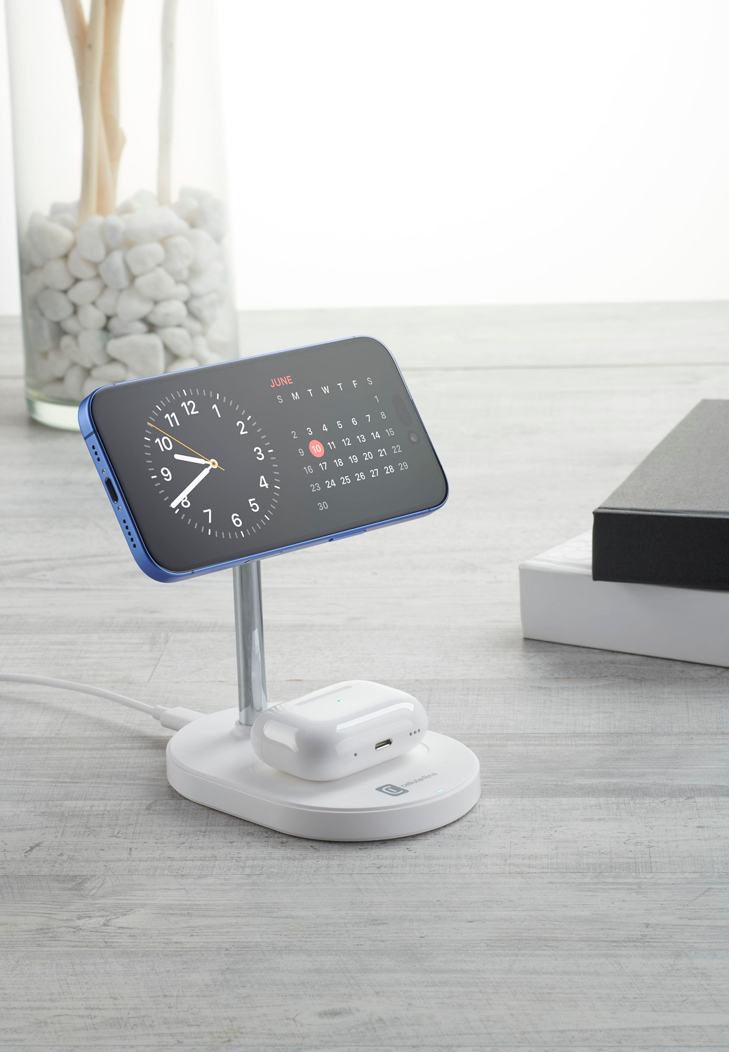 Un soporte de carga para teléfono con un teléfono y auriculares.